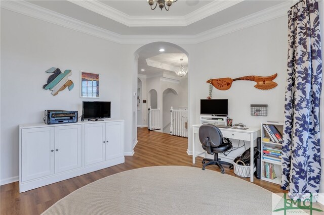 office space with a raised ceiling, dark hardwood / wood-style flooring, ornamental molding, and a notable chandelier