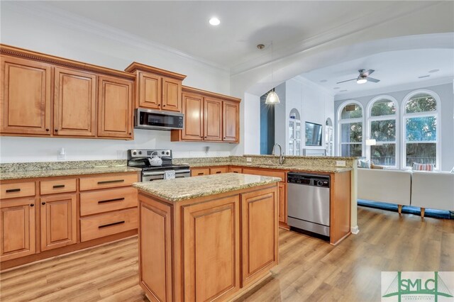 kitchen with a center island, stainless steel appliances, light hardwood / wood-style flooring, and hanging light fixtures