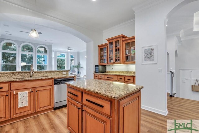 kitchen with dishwasher, light hardwood / wood-style floors, light stone countertops, and sink