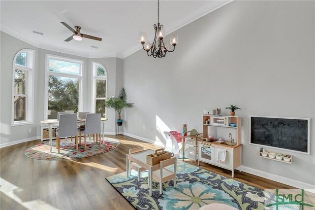 interior space featuring ceiling fan with notable chandelier, hardwood / wood-style flooring, and crown molding