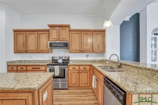 kitchen with pendant lighting, sink, light hardwood / wood-style floors, light stone counters, and stainless steel appliances