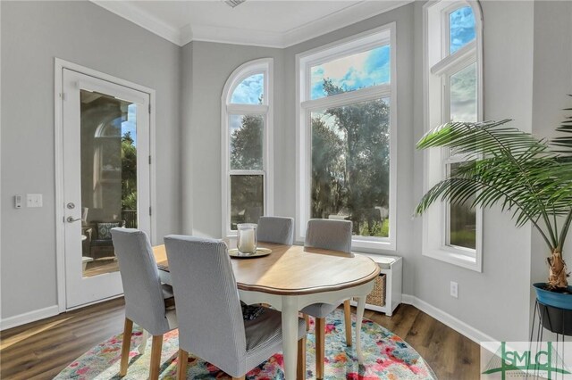 dining space with crown molding and dark wood-type flooring