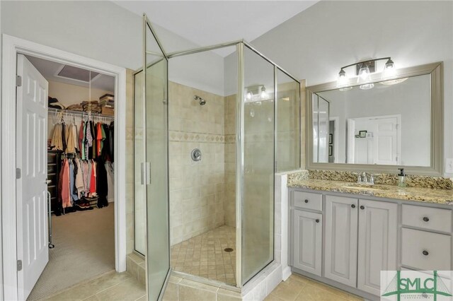 bathroom with vanity, tile patterned floors, and a shower with door