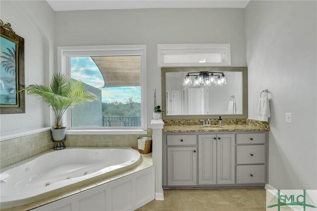 bathroom with tile patterned floors, vanity, and tiled tub