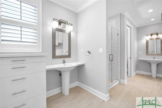 bathroom with wood-type flooring, a shower with shower door, and ornamental molding