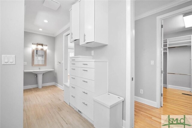 walk in closet with light hardwood / wood-style flooring