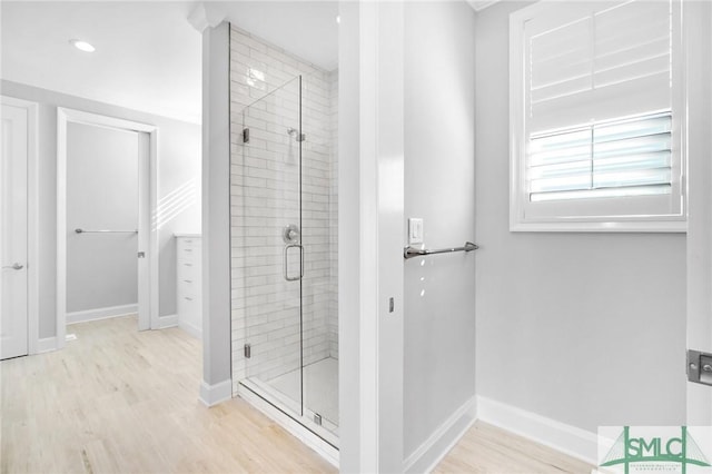 bathroom featuring hardwood / wood-style flooring and a shower with door