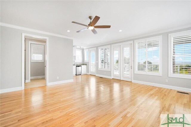 unfurnished living room with light hardwood / wood-style floors, ceiling fan, a healthy amount of sunlight, and ornamental molding