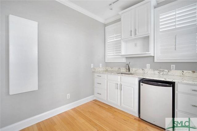 kitchen with dishwasher, white cabinetry, light stone countertops, and sink