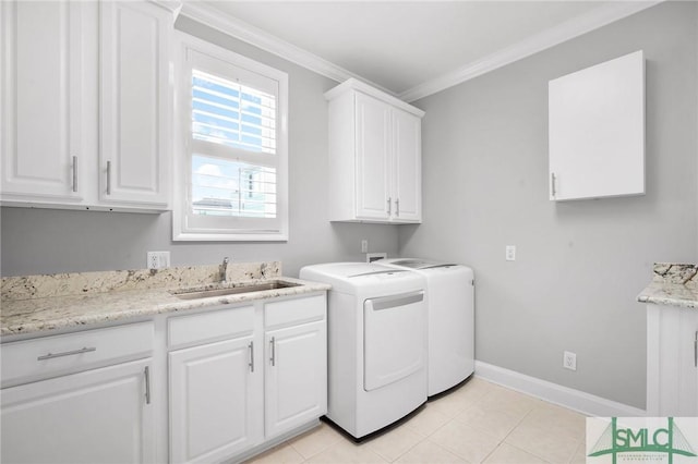 laundry room featuring washer and clothes dryer, cabinets, light tile patterned floors, and sink