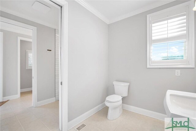 bathroom with tile patterned floors, ornamental molding, and toilet