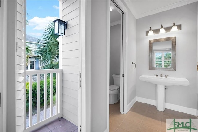 bathroom with tile patterned floors, toilet, and crown molding