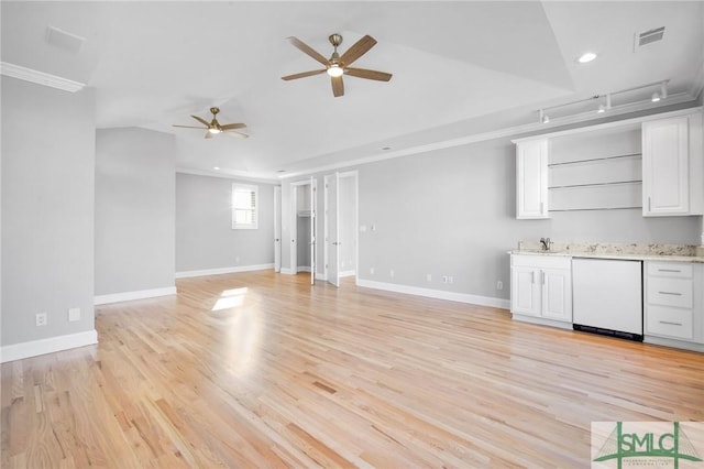 unfurnished living room with rail lighting, light hardwood / wood-style floors, crown molding, and sink