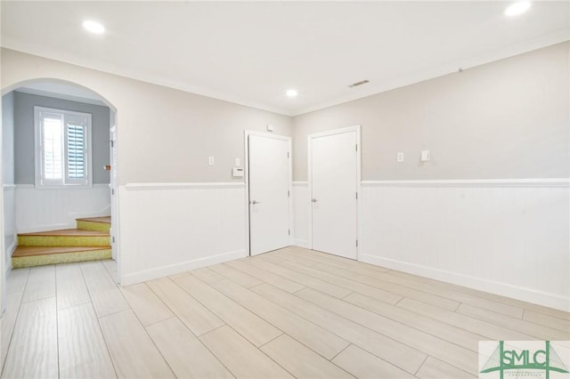 spare room featuring light hardwood / wood-style floors and ornamental molding