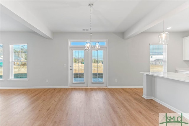 unfurnished dining area featuring beamed ceiling, an inviting chandelier, light hardwood / wood-style flooring, and a healthy amount of sunlight