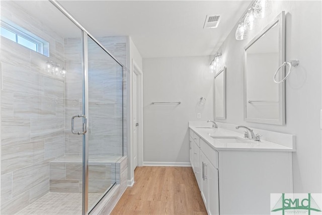 bathroom with vanity, hardwood / wood-style flooring, and a shower with shower door