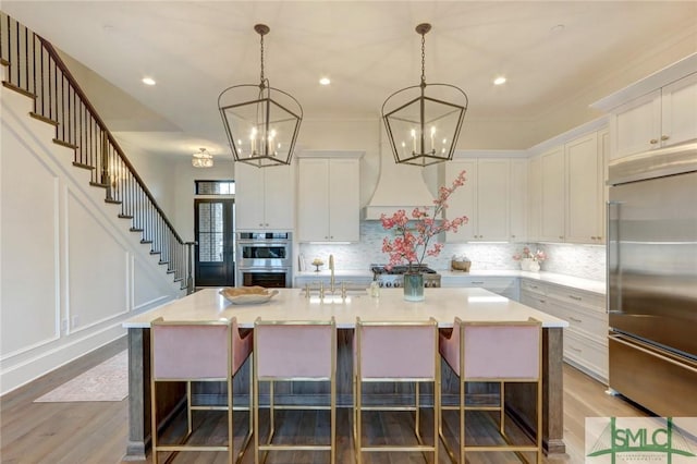 kitchen featuring white cabinets, an island with sink, and appliances with stainless steel finishes