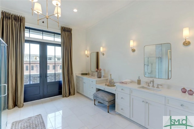 bathroom with french doors, tile patterned floors, ornamental molding, vanity, and an inviting chandelier