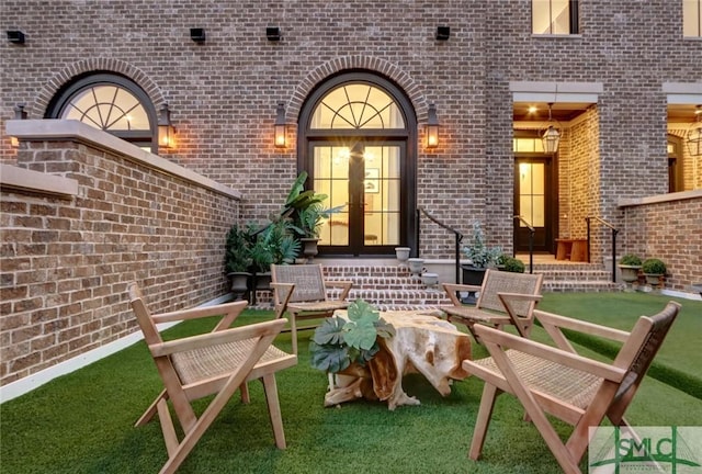 property entrance featuring a yard and french doors