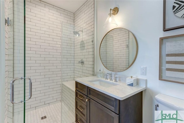 bathroom with vanity, a shower with shower door, and toilet