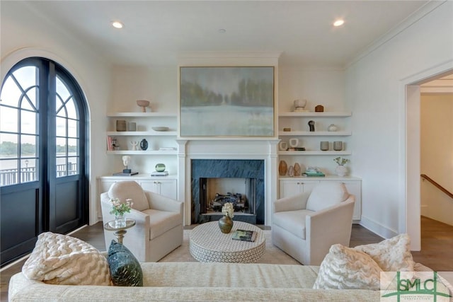 living room featuring crown molding, a fireplace, and light hardwood / wood-style flooring