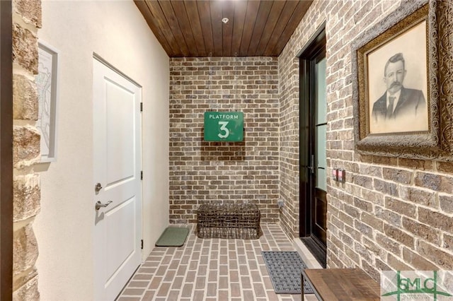 corridor with wood ceiling and brick wall