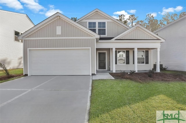 view of front of house featuring a garage, a front yard, and covered porch