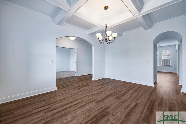 empty room with beam ceiling, ornamental molding, dark hardwood / wood-style floors, and a notable chandelier