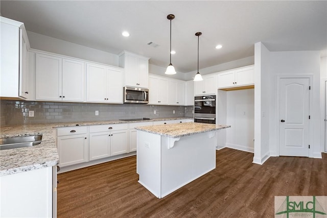 12 Cottonfield Dr, Guyton, GA 31312 - kitchen with stainless steel appliances, dark wood finished floors, white cabinets, a center island, and recessed lighting
