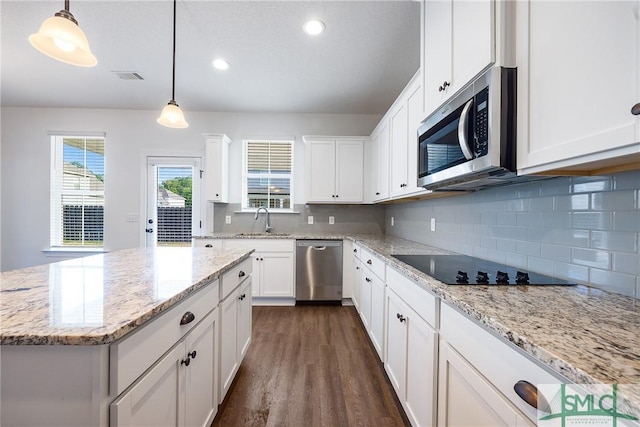12 Cottonfield Dr, Guyton, GA 31312 - kitchen featuring appliances with stainless steel finishes, tasteful backsplash, white cabinetry, dark wood-type flooring, and decorative light fixtures