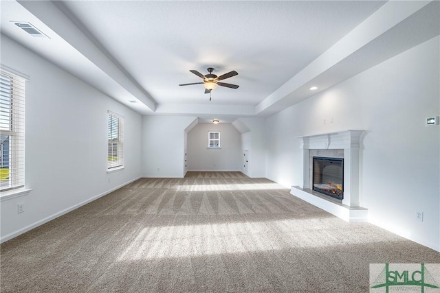 12 Cottonfield Dr, Guyton, GA 31312 - unfurnished living room with carpet floors, a ceiling fan, a raised ceiling, a glass covered fireplace, and recessed lighting