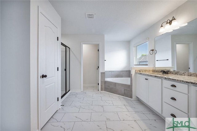 bathroom with vanity and shower with separate bathtub