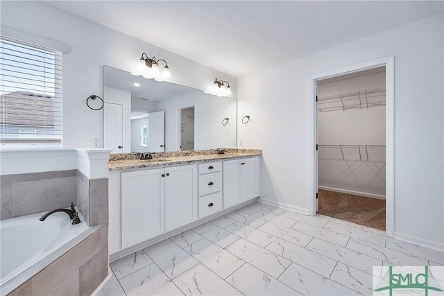 bathroom with vanity and a relaxing tiled tub