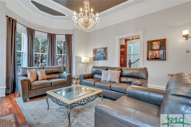 living room featuring hardwood / wood-style floors, a notable chandelier, and ornamental molding