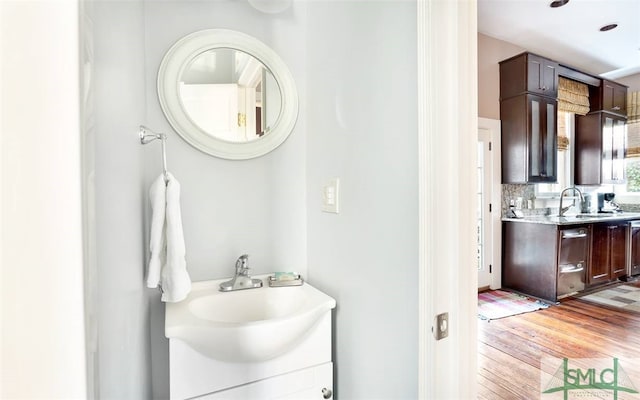 bathroom featuring wood-type flooring, vanity, and backsplash