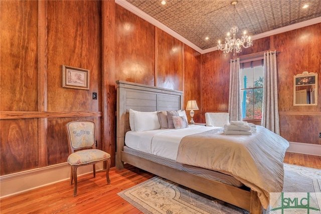 bedroom featuring crown molding, light hardwood / wood-style flooring, and a notable chandelier