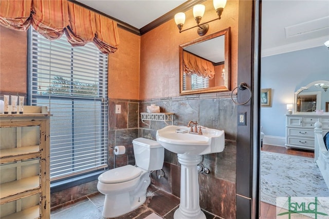 bathroom with toilet, tile walls, and crown molding