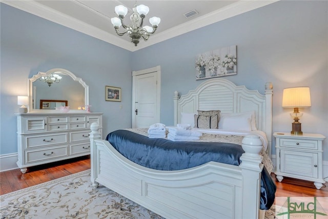 bedroom with light hardwood / wood-style floors, crown molding, and an inviting chandelier