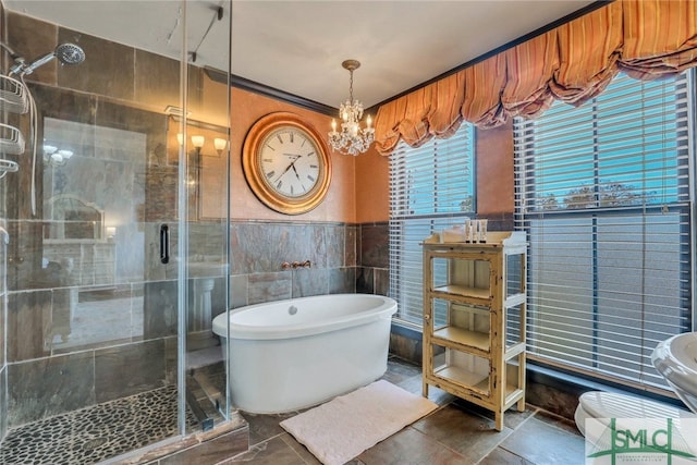 bathroom with plus walk in shower, ornamental molding, tile walls, and an inviting chandelier