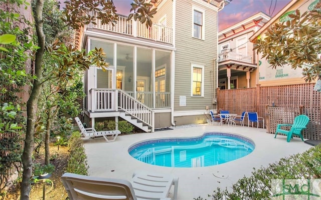 pool at dusk with a patio area