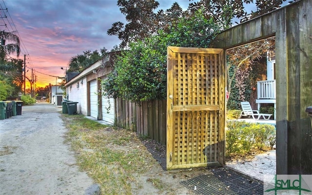 property exterior at dusk with an outdoor structure and a garage