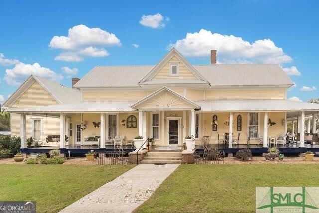 country-style home with a front yard and a porch