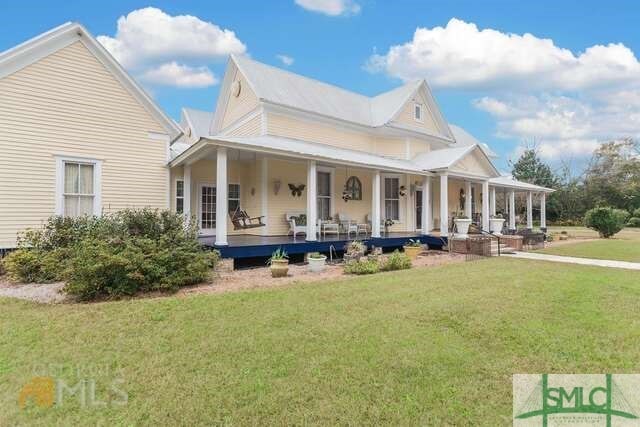 farmhouse-style home with a front yard and covered porch