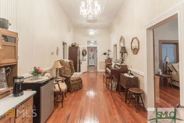 hallway with a chandelier and light wood-type flooring