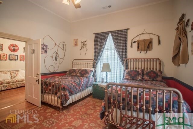 bedroom with ceiling fan, crown molding, and hardwood / wood-style flooring