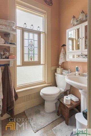 bathroom featuring tile flooring, a wealth of natural light, and toilet