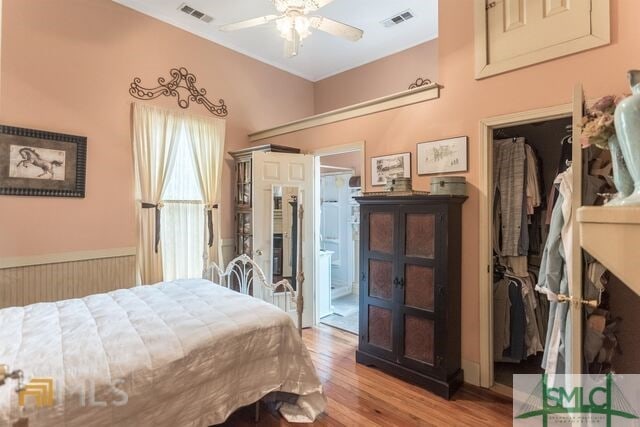 bedroom featuring ceiling fan, ensuite bath, and light hardwood / wood-style floors