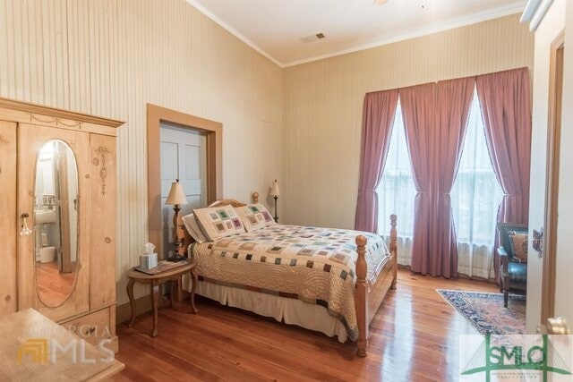 bedroom with hardwood / wood-style flooring and crown molding