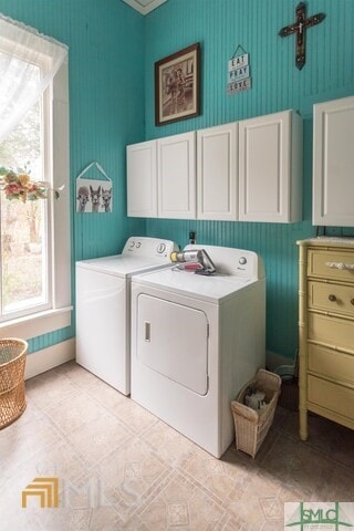 clothes washing area featuring washing machine and dryer, cabinets, and light tile floors