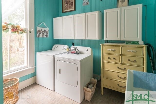 washroom featuring cabinets, separate washer and dryer, and light tile floors